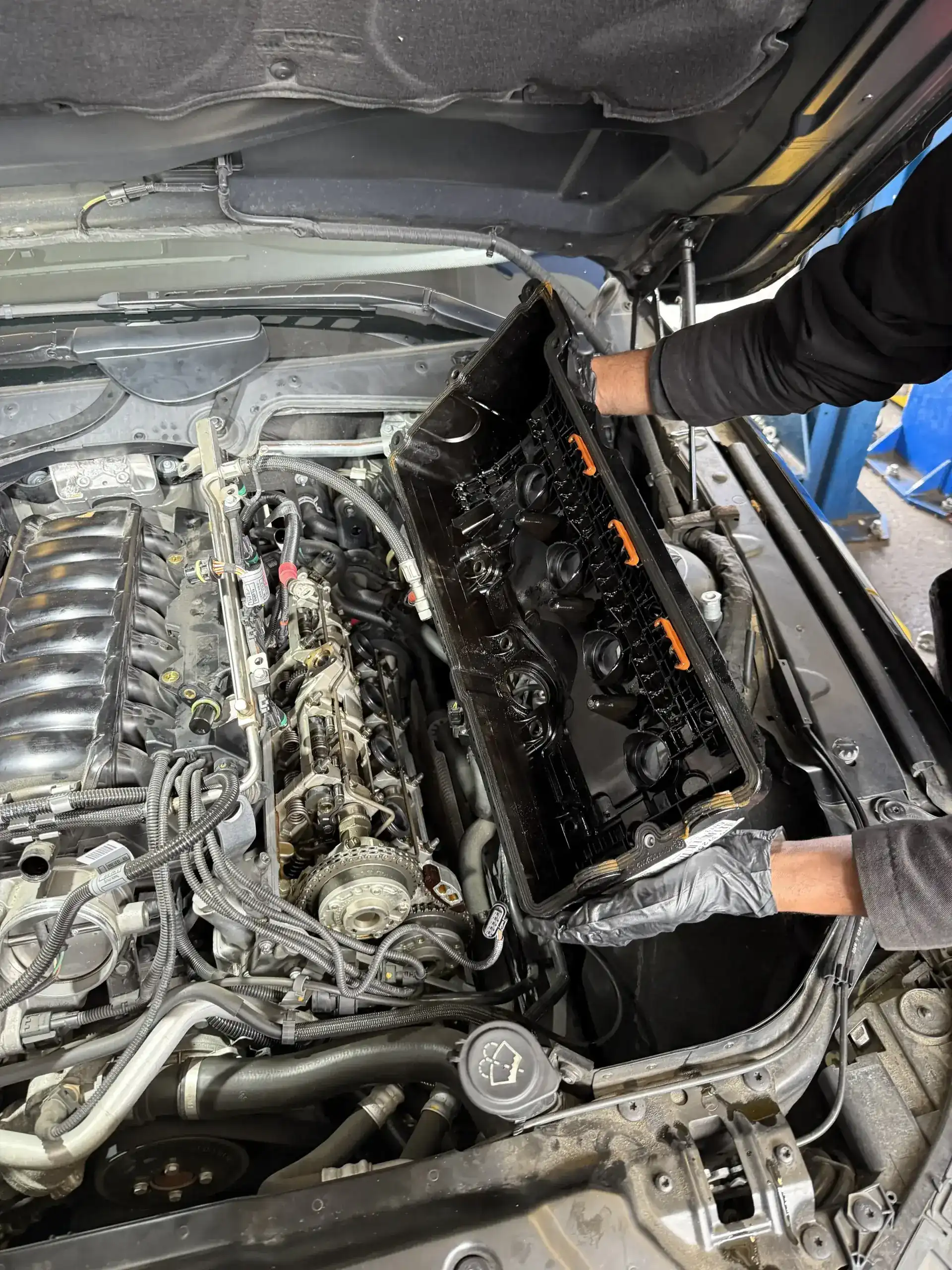 BMW V8 valve cover removed showing camshafts during cooling-system-adjacent service at Beacon Auto Care San Mateo